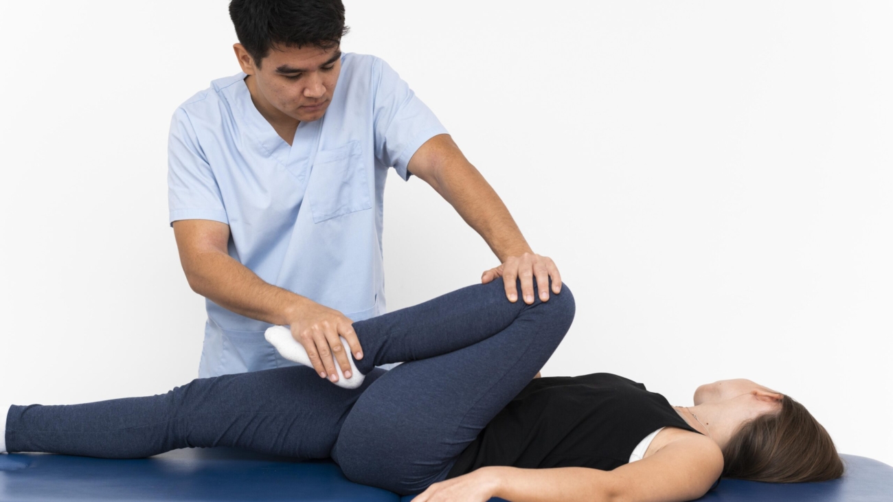 physiotherapist-doing-leg-exercises-with-female-patient